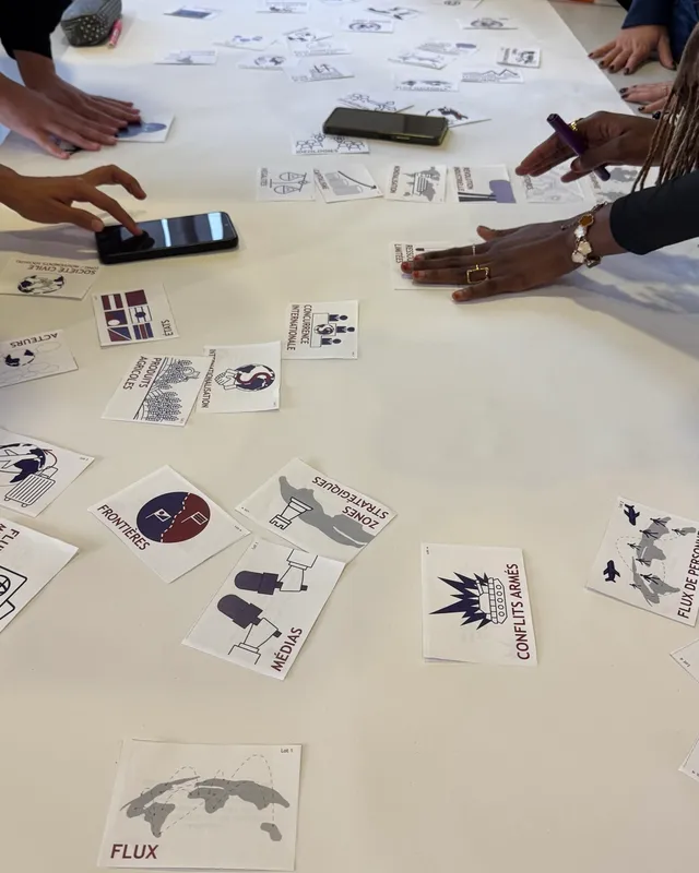 Cartes de la Fresque de la géopolitique posées sur une grande table