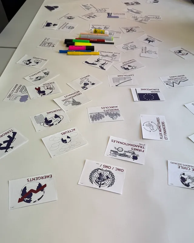 Cartes de la Fresque de la géopolitique posées sur une grande table