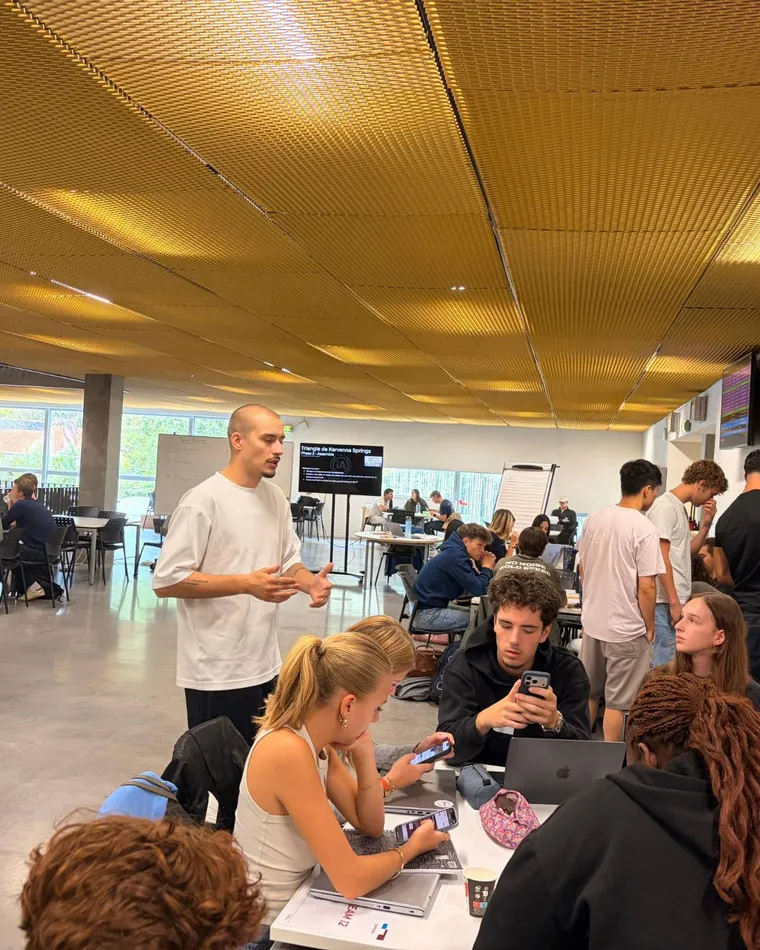 Étudiants en atelier dans un grand espace sous un plafond doré