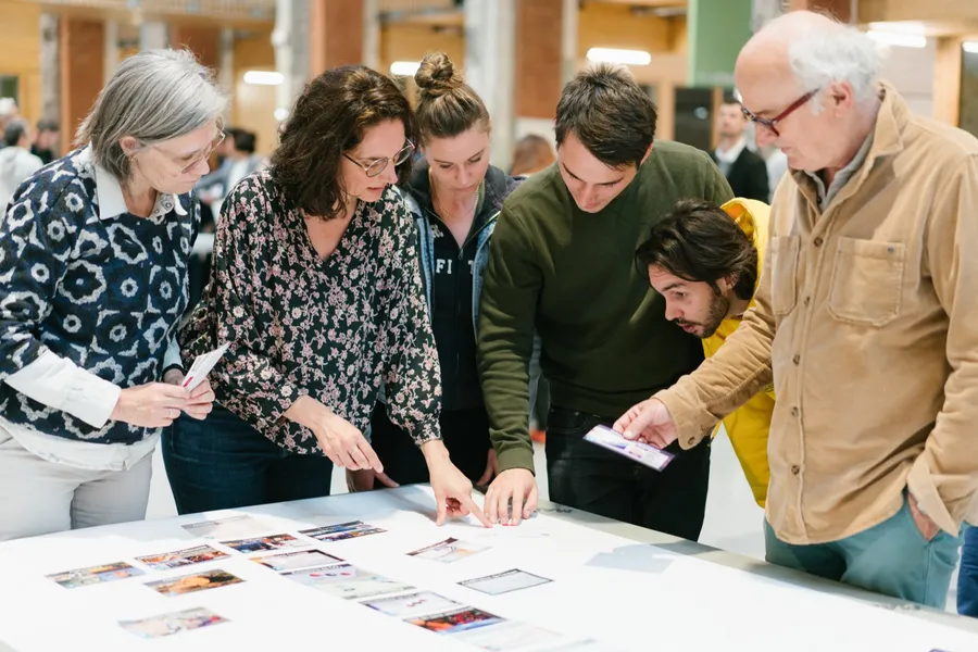 Participants penchés sur les cartes posées sur la table