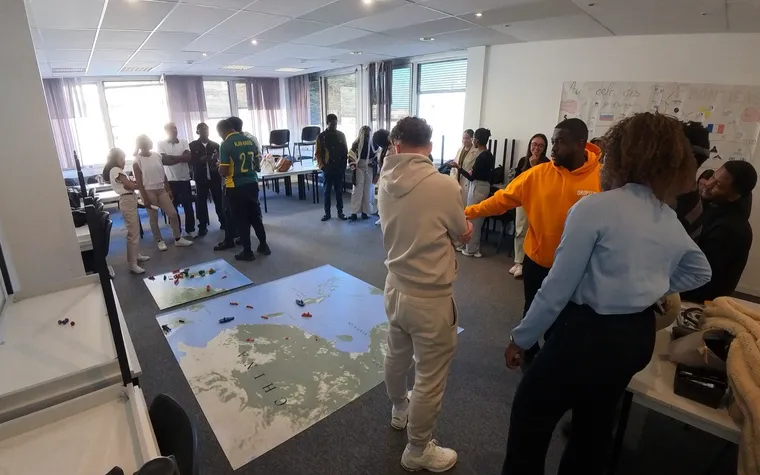 Participants autour d’une grande carte au sol pendant le wargame